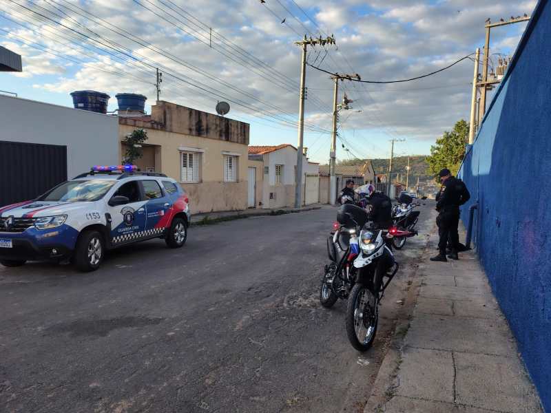 Viatura da Guarda Civil Municipal interrompida em uma rua, com agentes de segurança ao lado de motos estacionadas, durante operação de segurança.