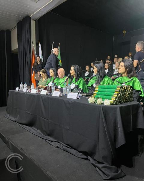 Cerimônia de colação de grau na Escola Técnica do Complexo de Saúde São João de Deus, com membros da mesa, formandos e convidados celebrando a conclusão do curso técnico em Enfermagem.