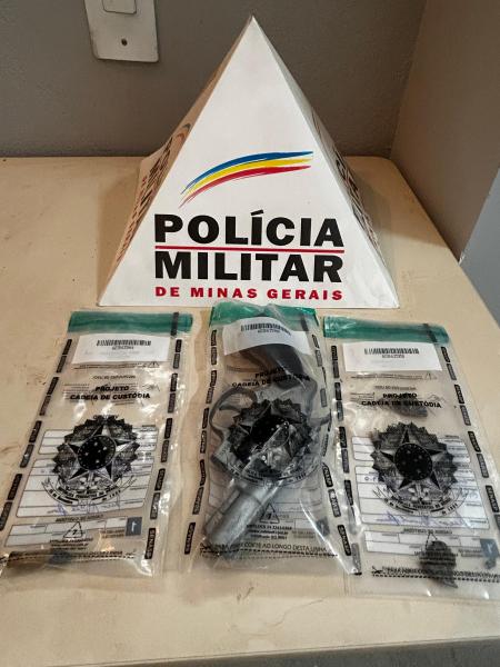 Pólicia Militar de Minas Gerais, triângulo de sinalização e dois revólveres em embalagens de custódia.