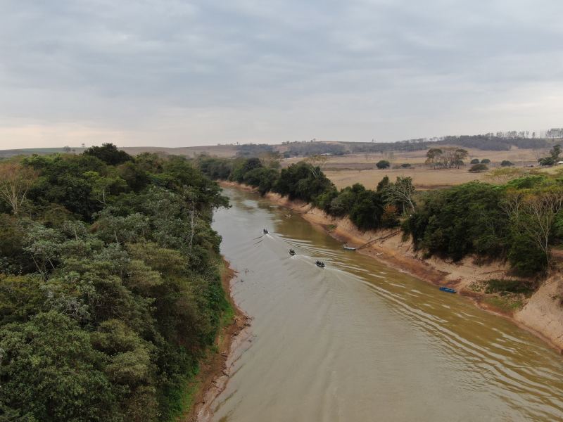 Vista aérea do Rio São Francisco com vegetação ao longo das margens e embarcações navegando.