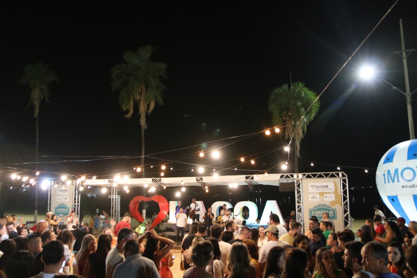 Público reunido no Festival do Peixe de Lagoa da Prata, com palco iluminado e decoração noturna, evidenciando a celebração gastronômica.