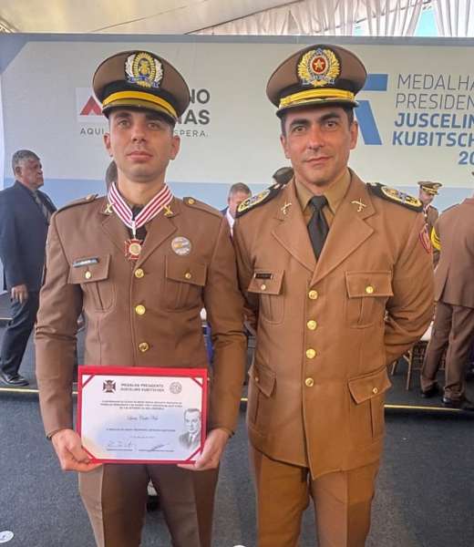Cabo Lucas Costa Neto, condecorado com a Medalha Presidente Juscelino Kubitschek, posando com um oficial da PMMG durante cerimônia em Diamantina.