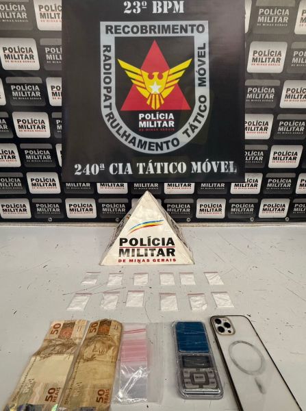 Imagem de um tablete com o logotipo da Polícia Militar e materiais apreendidos, incluindo dinheiro, pacotes de drogas e uma balança de precisão.