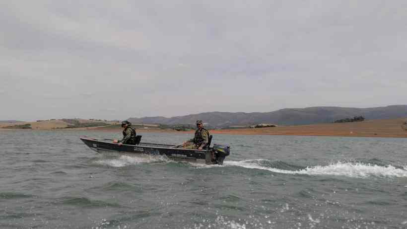 Membros da Polícia Militar de Meio Ambiente em uma embarcação durante operações de combate à pesca predatória em Minas Gerais.