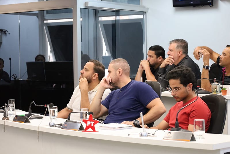 Vereadores assistindo a uma audiência pública na Câmara Municipal de Divinópolis, discutindo orçamento e planejamento.