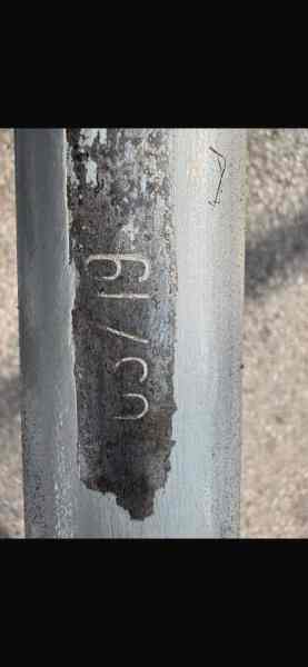Close-up of a metal surface showing a partially obscured engraving of the numbers '03719' and signs of wear and corrosion.