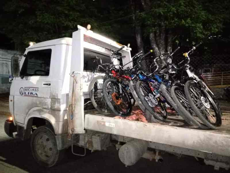 Caminhão plataforma transportando várias motocicletas apreendidas durante operação policial.