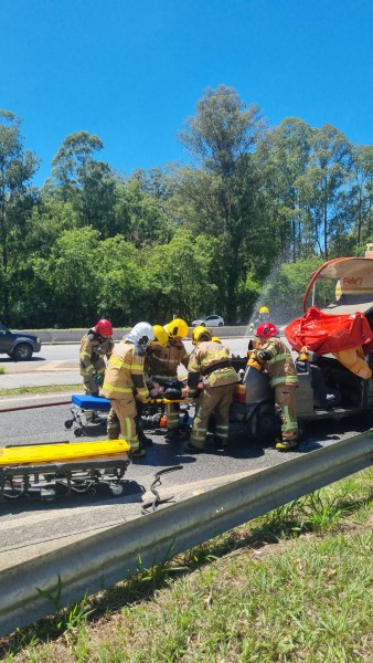 Bombeiros realizando atendimento de emergência durante simulado de acidente com produtos perigosos na rodovia MG-050, com equipes trabalhando em conjunto.