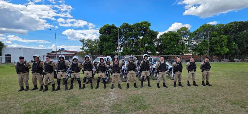 Grupo de policiais do 63º Batalhão de Polícia Militar em formação, com motocicletas, em ambiente aberto sob céu azul com nuvens, durante a Operação Cavalo de Aço.