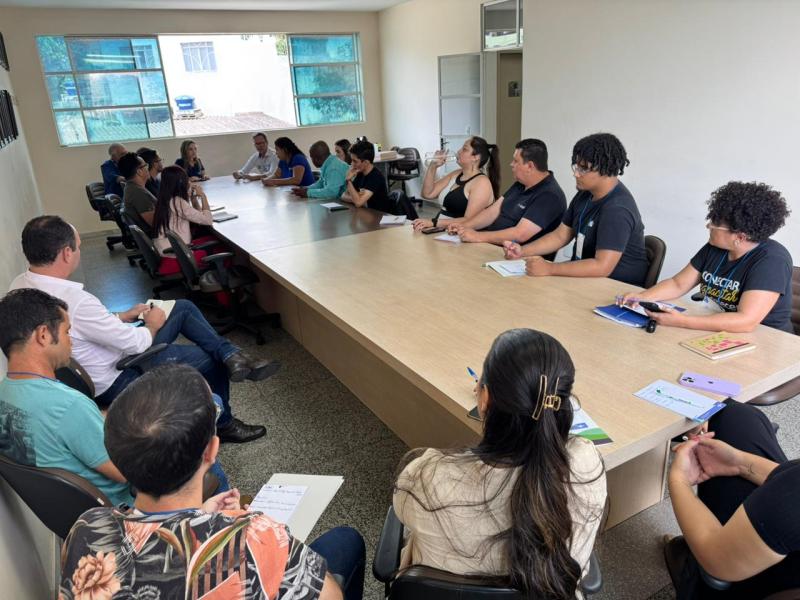 Participantes do Curso de Captação de Recursos discutem em mesa grande em ambiente de treinamento.