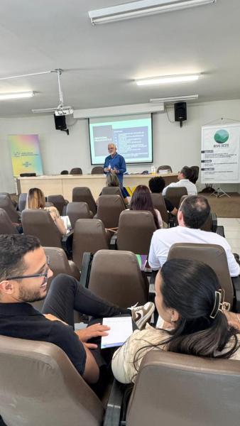 Sala de aula com participantes em um curso sobre captação de recursos, com um palestrante à frente apresentando conteúdo em uma tela.