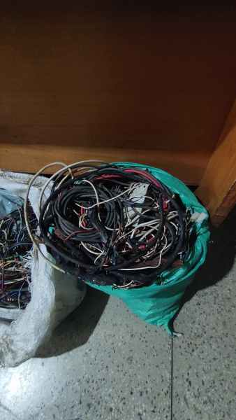 Um saco verde cheio de fios de cobre emaranhados, possivelmente apreendidos em uma operação policial.