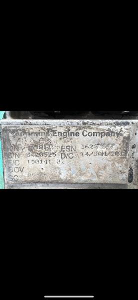 Placa de um motor da empresa 'Marine Engine Company' com informações de serial e modelo, mostrando sujeira e desgaste.