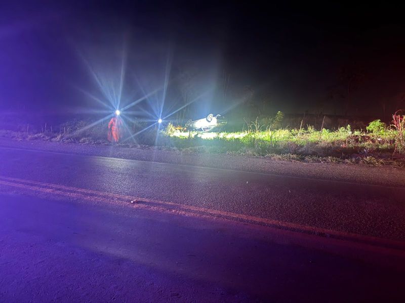 Veículo capotado às margens da BR-354 à noite, com equipes de resgate utilizando lanternas em busca de vítimas.