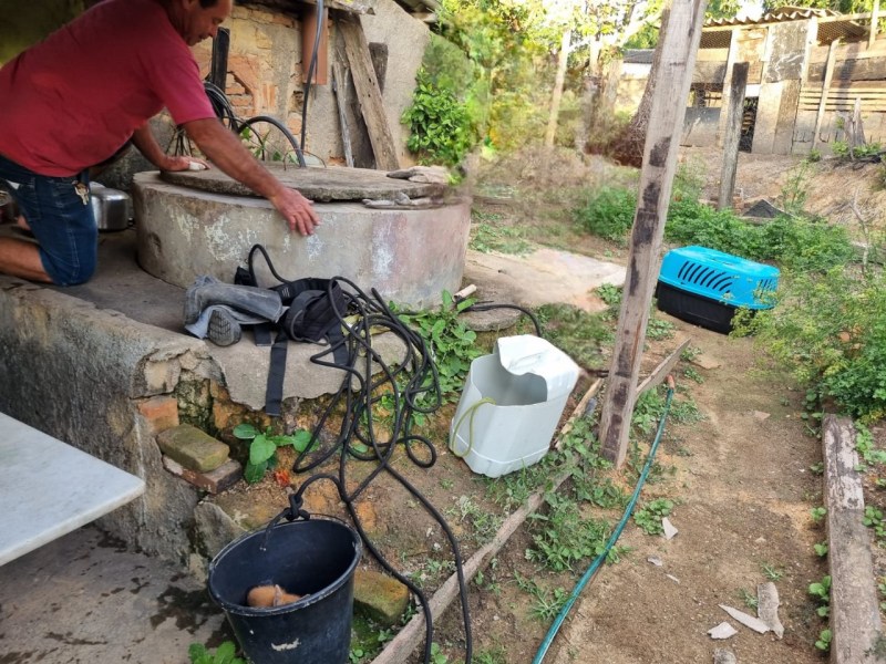 Homem próximo a uma cisterna desativada em uma zona rural, preparando-se para um resgate