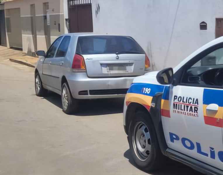 Imagem de um veículo estacionado em uma rua e uma viatura da Polícia Militar ao lado, destacando ações de recuperação de veículos roubados.