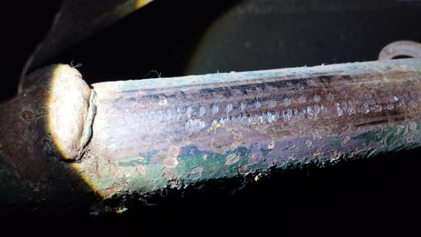 Close-up of a metal surface showing signs of grinding and lack of chassis number, indicating possible vehicle identification tampering.