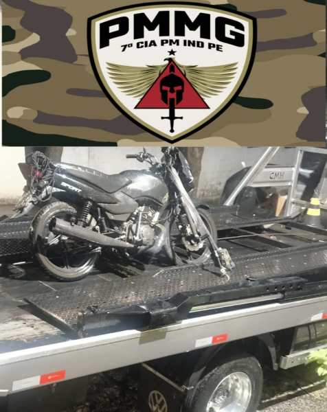 Motocicleta apreendida pela Polícia Militar, carregada em uma plataforma de guincho, com o emblema da PMMG ao fundo.