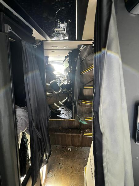 Interior de um ônibus com visibilidade de pessoas sentadas e um ambiente bagunçado.