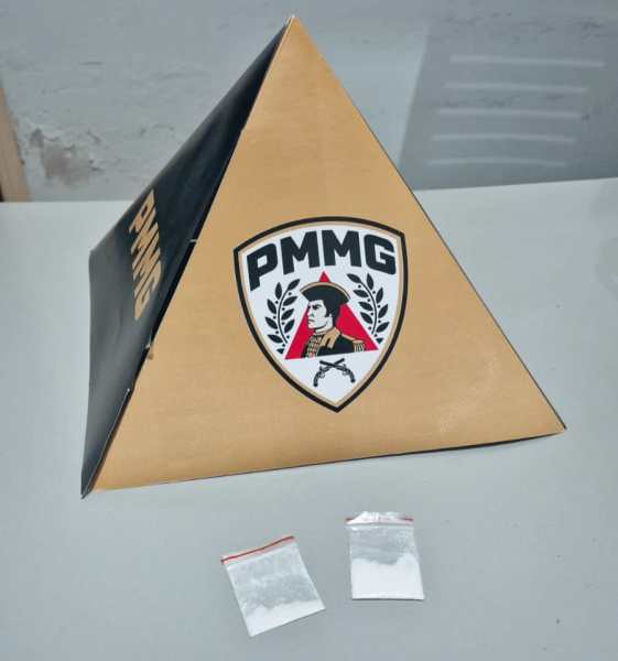 Piramide com o logotipo PMMG ao lado de dois pacotes contendo substância branca.