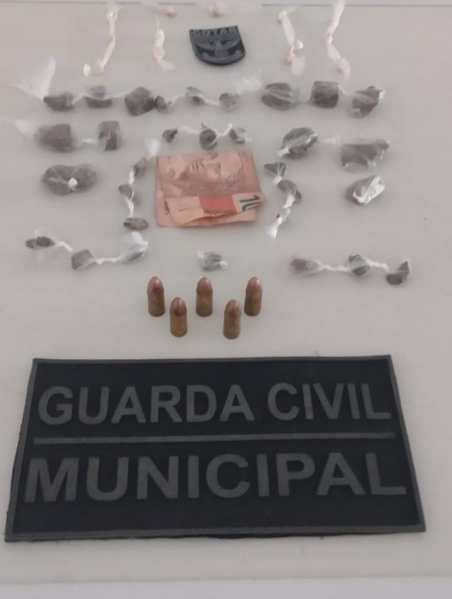 Requintos da Guarda Civil Municipal, incluindo drogas, munições e uma nota de dinheiro.