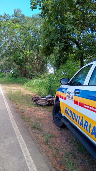 Veículo da Polícia Rodoviária estacionado ao lado da estrada com uma bicicleta caída no chão e vegetação ao fundo.