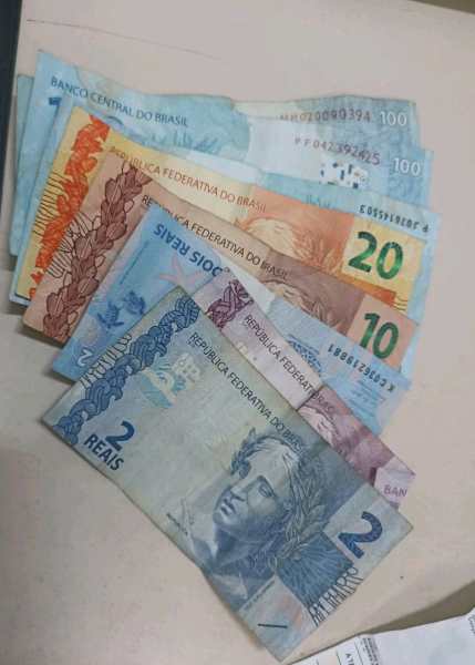 Notas de dinheiro brasileiro de diferentes denominações, incluindo R$ 2, R$ 10, R$ 20 e R$ 100.