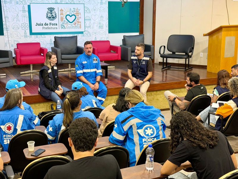 Reunião em Juiz de Fora com profissionais de emergência e autoridades, onde discutem ações de socorro e prevenção.