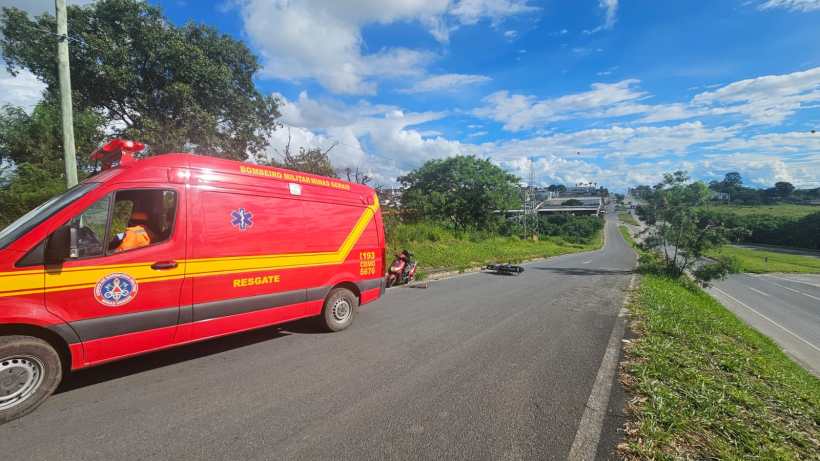 Veículo de emergência do Corpo de Bombeiros estacionado na estrada, com uma pessoa sentada ao lado e o cenário de uma rodovia ao fundo.