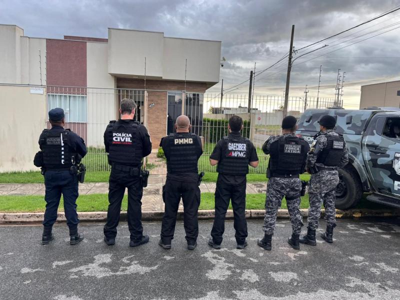 Grupo de policiais em frente a uma residência, com armas e uniformes de diferentes forças policiais.
