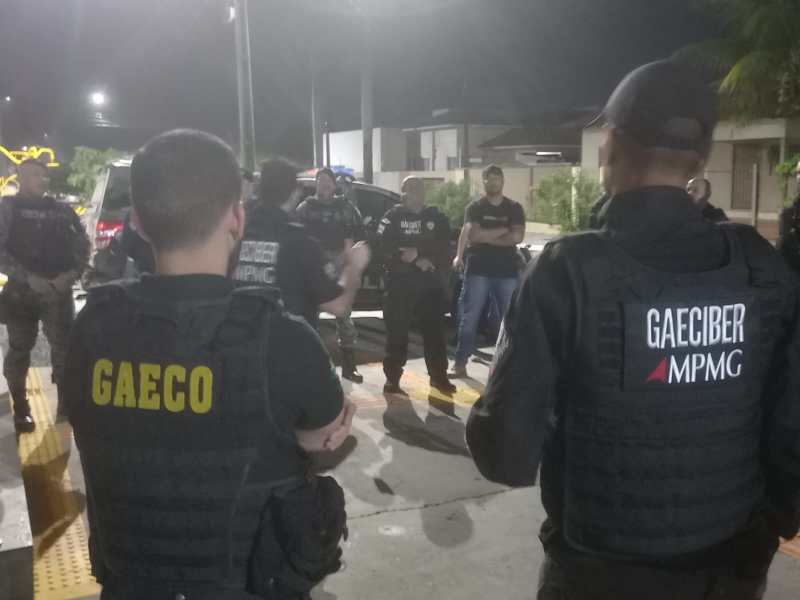 Agentes da força de segurança em reunião à noite, discutindo estratégias de operações em área urbana.