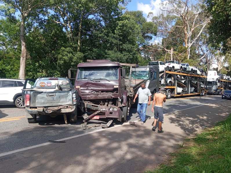 Acidente de trânsito envolvendo um caminhão e uma caminhonete, com pessoas inspecionando os veículos na estrada.