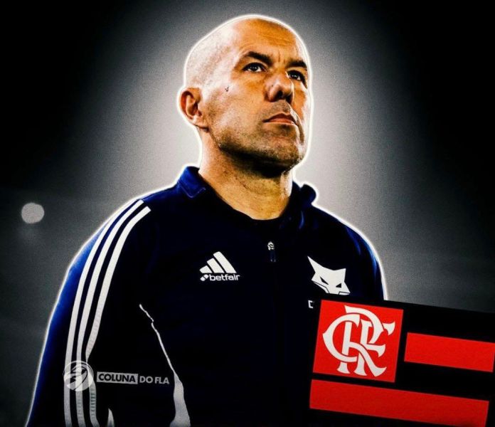 A man in a dark tracksuit stands confidently, holding a flag with the Flamengo logo, showcasing determination and focus.