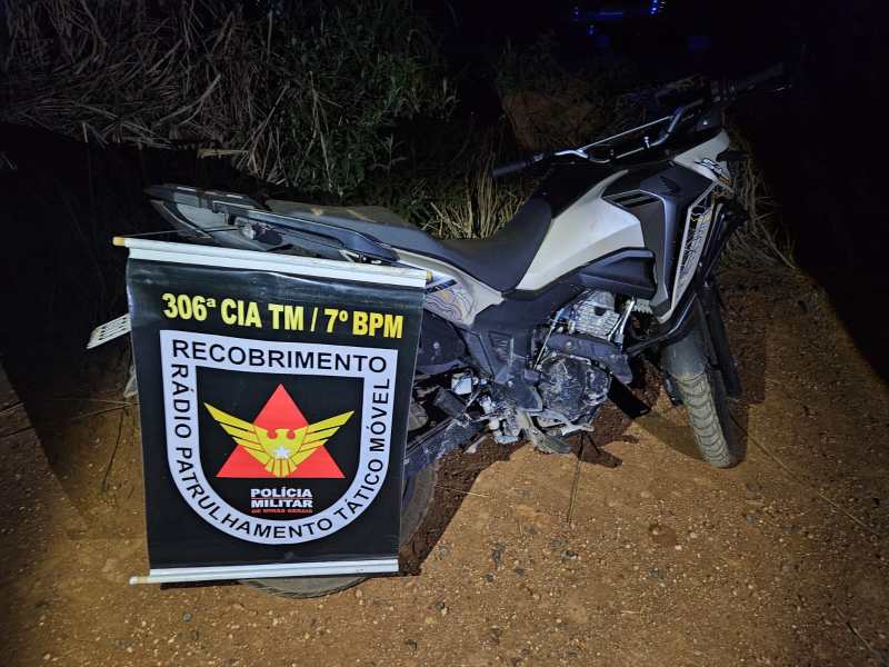 Motocicleta da Polícia Militar com placa exibindo informações da 306ª CIA TM / 7º BPM em uma área escura.
