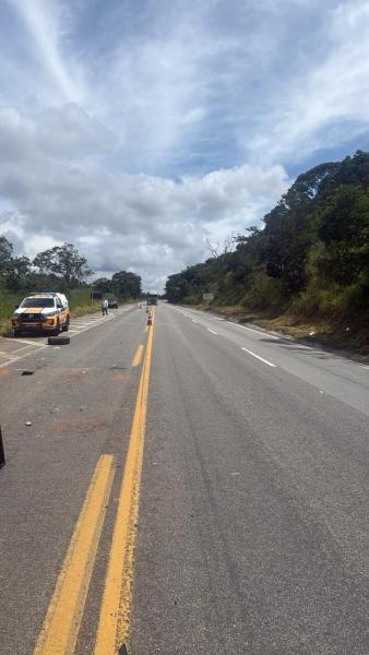 Estrada em manutenção com um veículo de emergência estacionado na lateral.