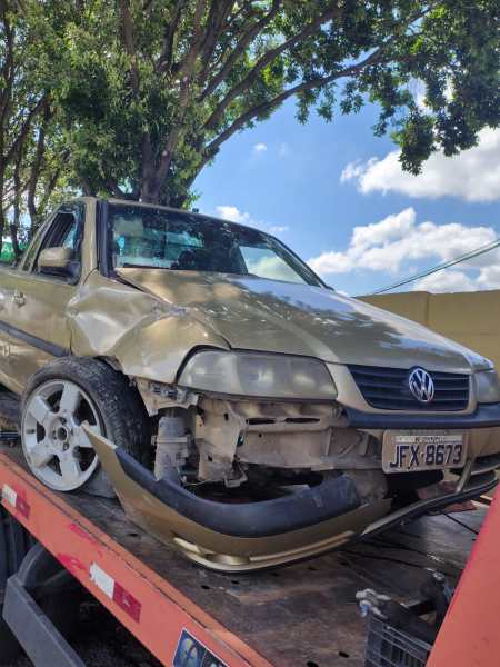 Carro Volkswagen danificado em um reboque com corpo amassado e rodado visível.