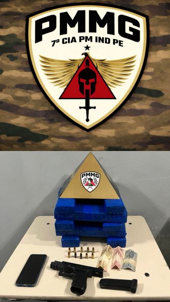 Emblema da PMMG com o texto '7ª CIA PM IND PE' no fundo camuflado, acompanhado de uma mesa exibindo uma arma, munições, dinheiro e um celular.