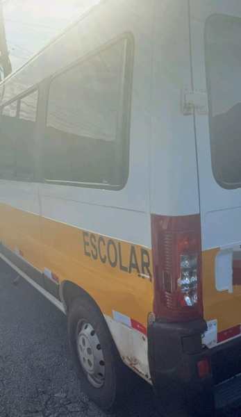 Veículo escolar estacionado, com a inscrição 'ESCOLAR' em destaque na lateral.