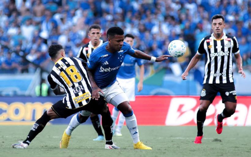 A soccer match in progress featuring players in blue and black and white uniforms with a ball in play.