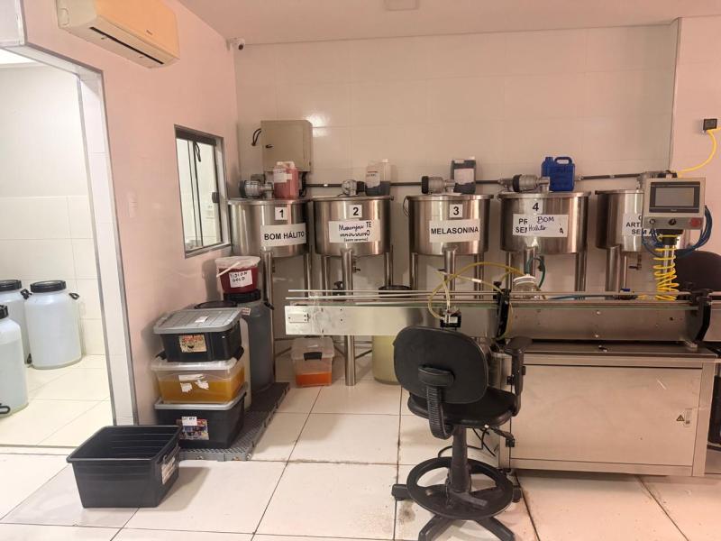 Laboratório com equipamentos de medição e frascos de soluções, incluindo recipientes etiquetados como BOM HÁLITO, Melatonina, e outros.