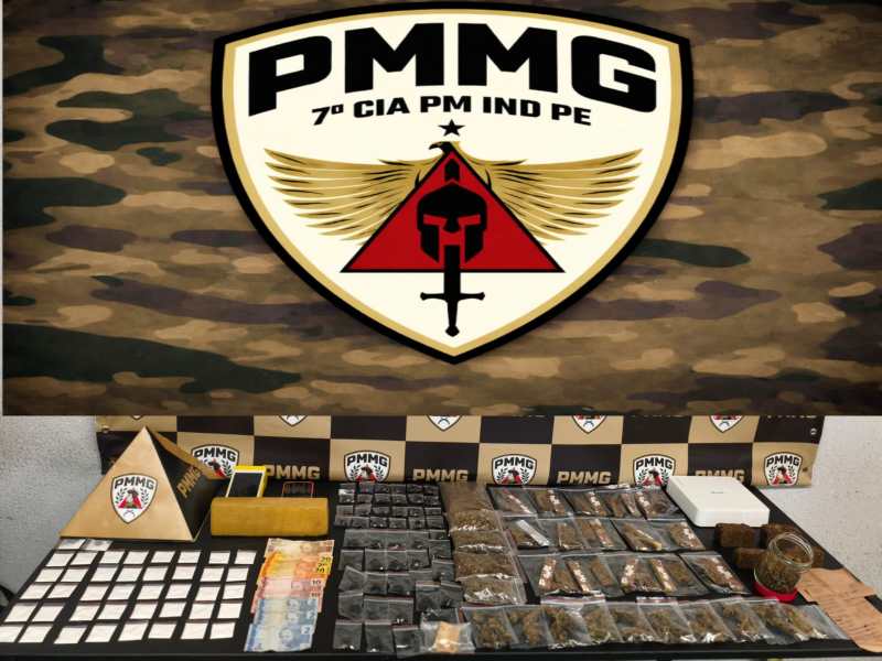 Logotipo da PMMG (Polícia Militar de Minas Gerais) com materiais apreendidos, incluindo drogas e dinheiro em uma mesa.