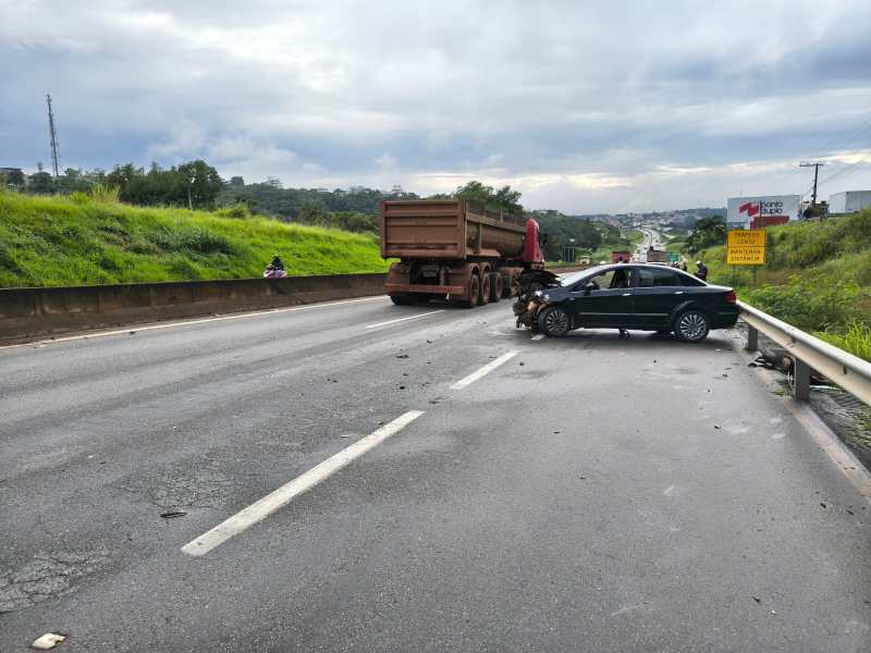 Acidente de trânsito envolvendo um carro e um caminhão na estrada, com detritos espalhados pela pista.