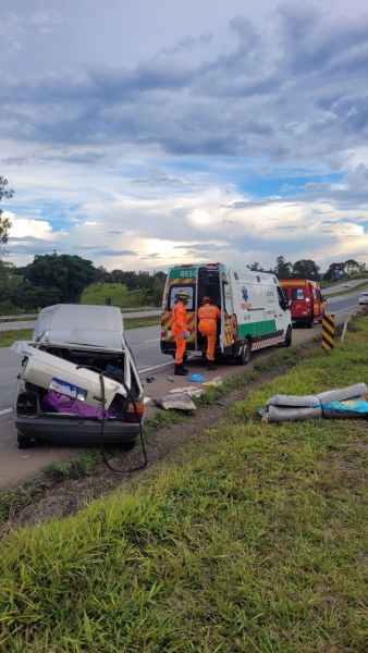 Acidente de carro na estrada com veículos de emergência e profissionais de resgate trabalhando.