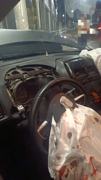 Interior de um carro danificado, com o painel removido e um airbag ativado visível.