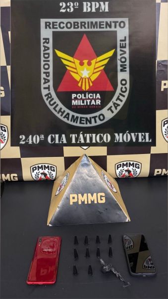 Produtos apreendidos pela Polícia Militar, incluindo dois celulares, uma chave e seis objetos não identificados, com fundo do logo da Polícia Militar de Minas Gerais.