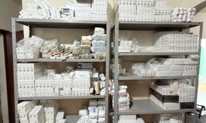 Prateleiras com diversos medicamentos organizados em caixas, com embalagem visível e rótulos em português.