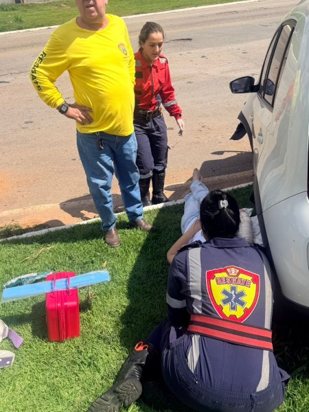 Equipe de emergência prestando assistência a uma pessoa em situação de emergência, com paramédicos e civis envolvidos.