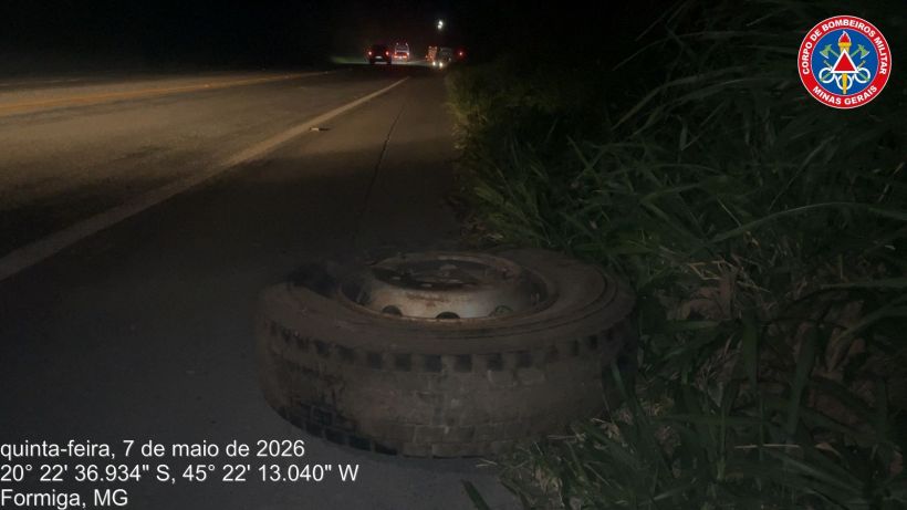 Roda de pneu abandonada na beira da estrada à noite em Formiga, MG.