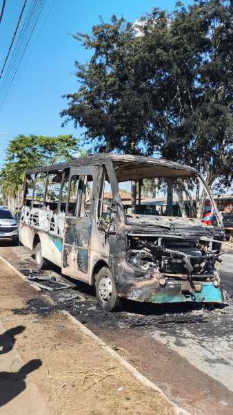 Ônibus queimado estacionado na rua, com chassi exposto e danos visíveis devido ao incidente.