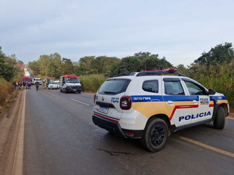 Viatura da polícia militar parada em estrada, com equipes de emergência e pessoas próximas ao local.